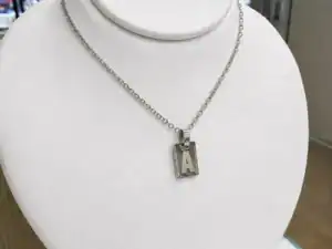 Chapita con inicial ACERO QUIRURGICO